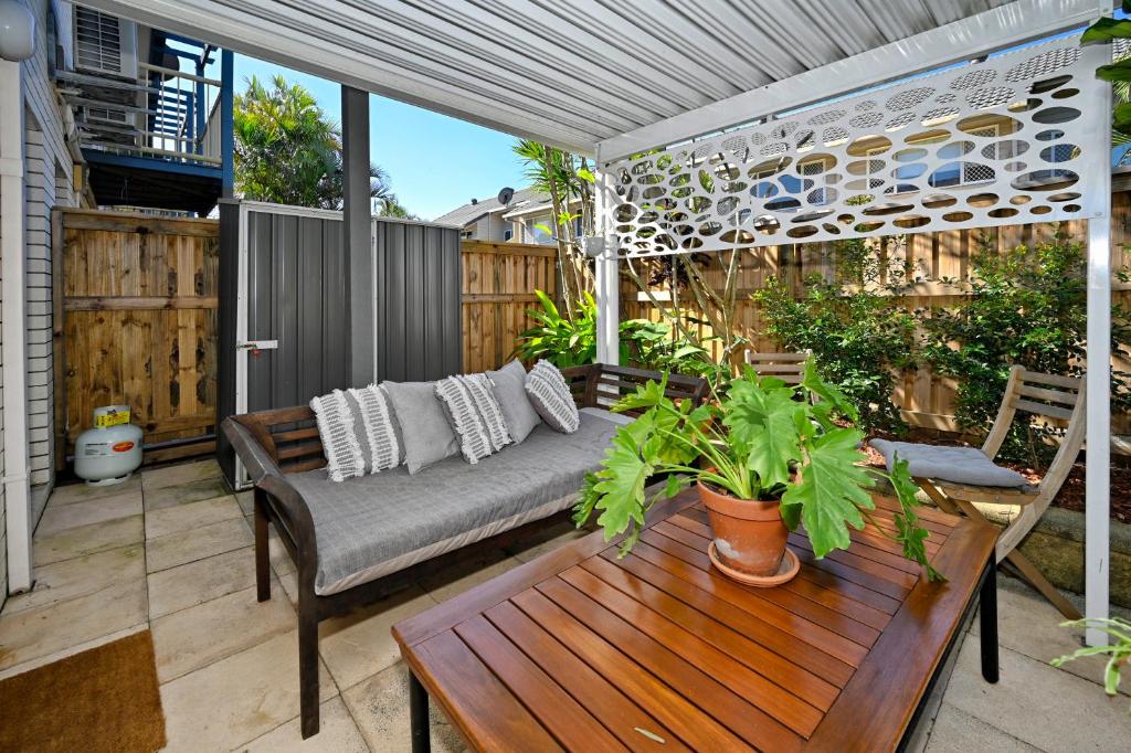 a patio with a couch and a table and a fence at Maroochydore 3 B/R, 2 Bath, Townhouse ZA4 in Maroochydore