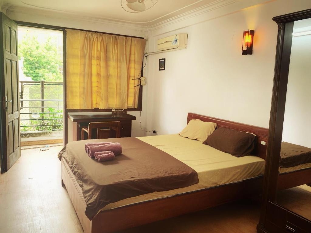 a bedroom with a bed in a room with a window at Rainbow HomeStay - No 8 Alley 18B Tong Dan in Hanoi