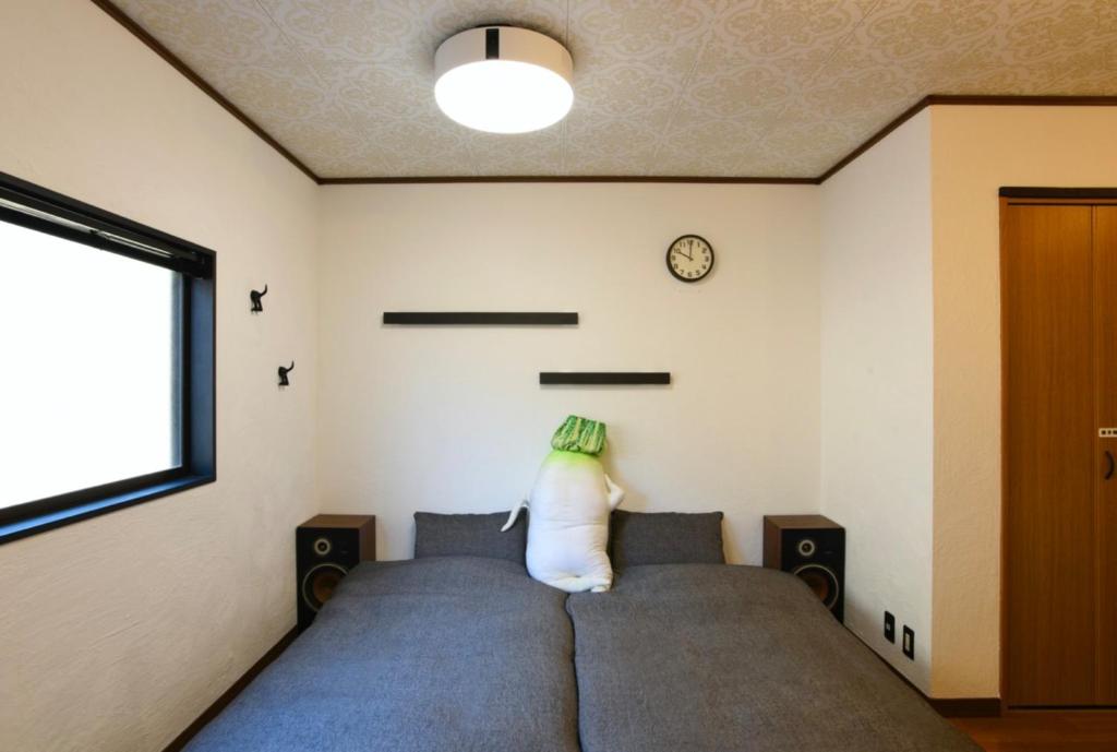 a bedroom with a bed and a clock on the wall at 一棟貸し平戸俺んち in Hirado