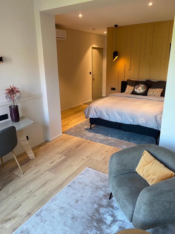 - une chambre avec un lit, un canapé et une chaise dans l'établissement Good Mood - chambres et suite, à Namur