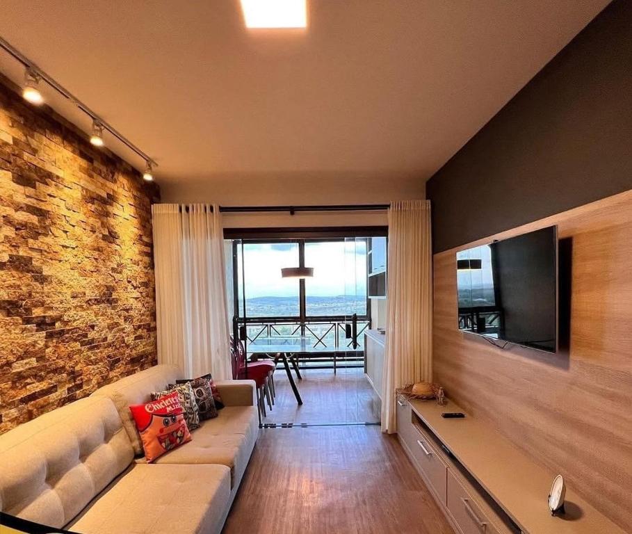 uma sala de estar com um sofá e uma televisão de ecrã plano em Flat com Churrasqueira Monte castelo em Bezerros