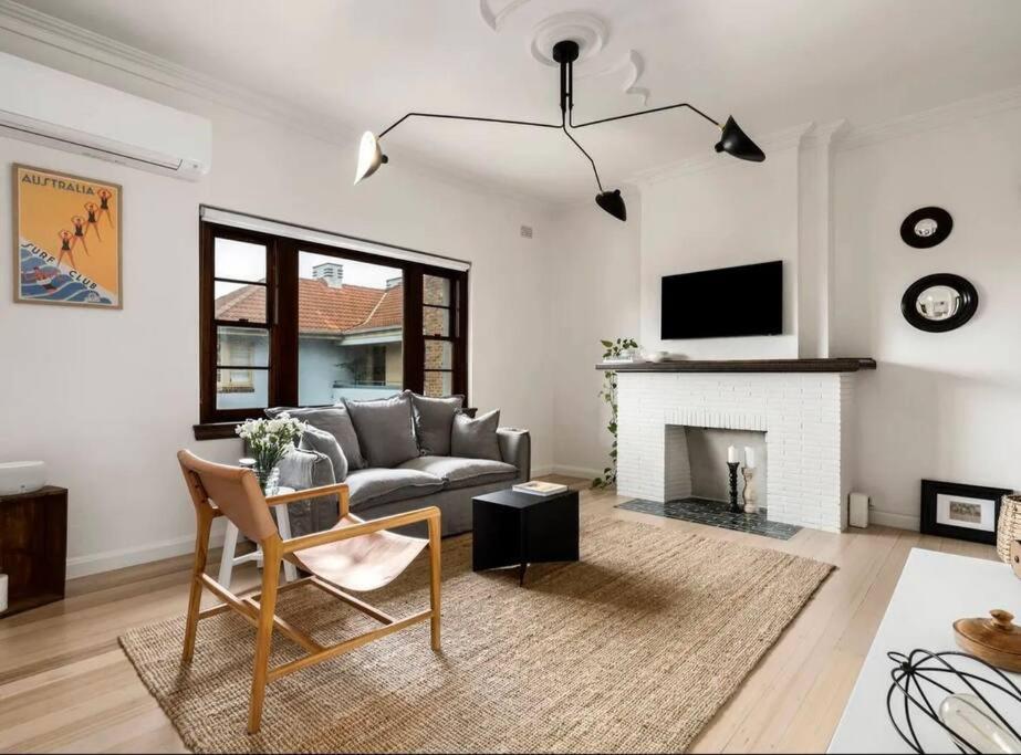 a living room with a couch and a fireplace at ‘Lynton-Sur-Mer’ - Beachside Apt with Heating in Melbourne
