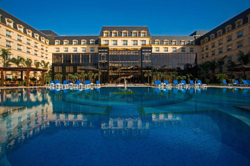 Renaissance Cairo Mirage City Hotel في القاهرة: مسبح كبير امام مبنى
