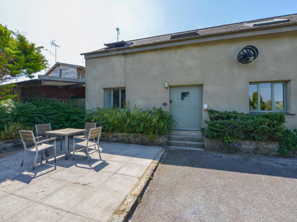 ein Tisch und Stühle vor einem Haus in der Unterkunft Oak Leaves Cottage in Newton Abbot