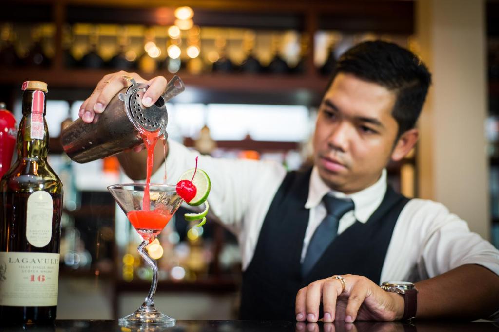 a man pouring a drink into a martini glass at Borei Angkor Resort & Spa in Siem Reap