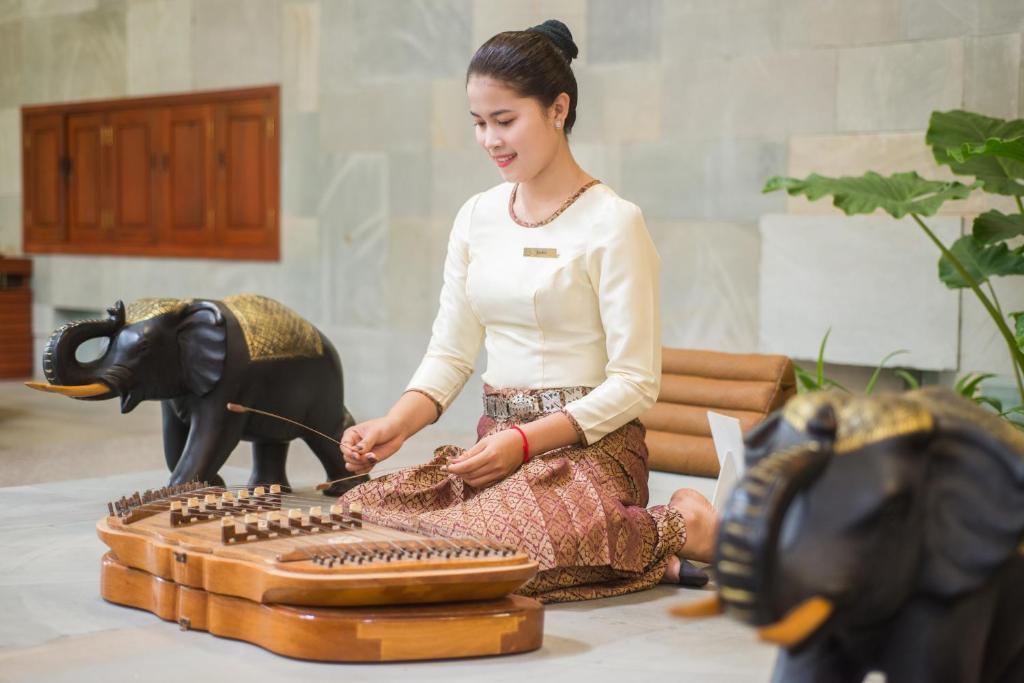 a woman is sitting next to a sewing machine at Borei Angkor Resort & Spa in Siem Reap