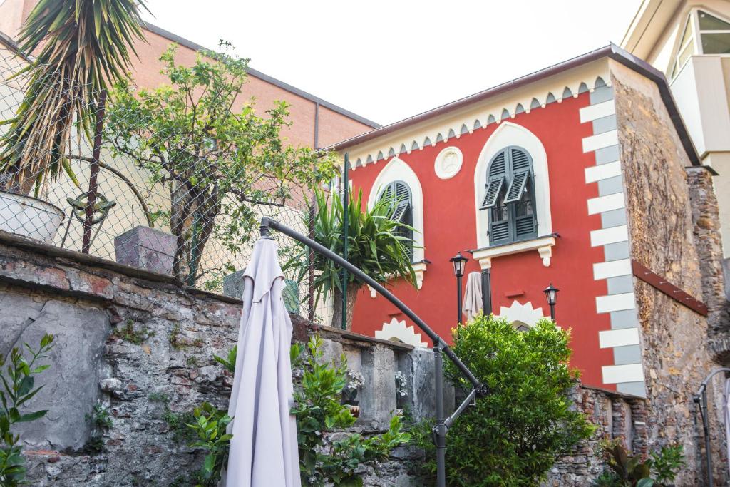 un bâtiment rouge avec un parapluie blanc devant lui dans l'établissement La CASETTA Antica dimora nel centro storico, à Chiavari