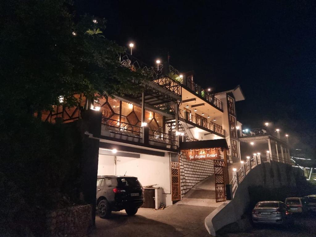ein Gebäude mit nachts auf einem Parkplatz geparkt in der Unterkunft Jai Anjana Resort in Kanatal