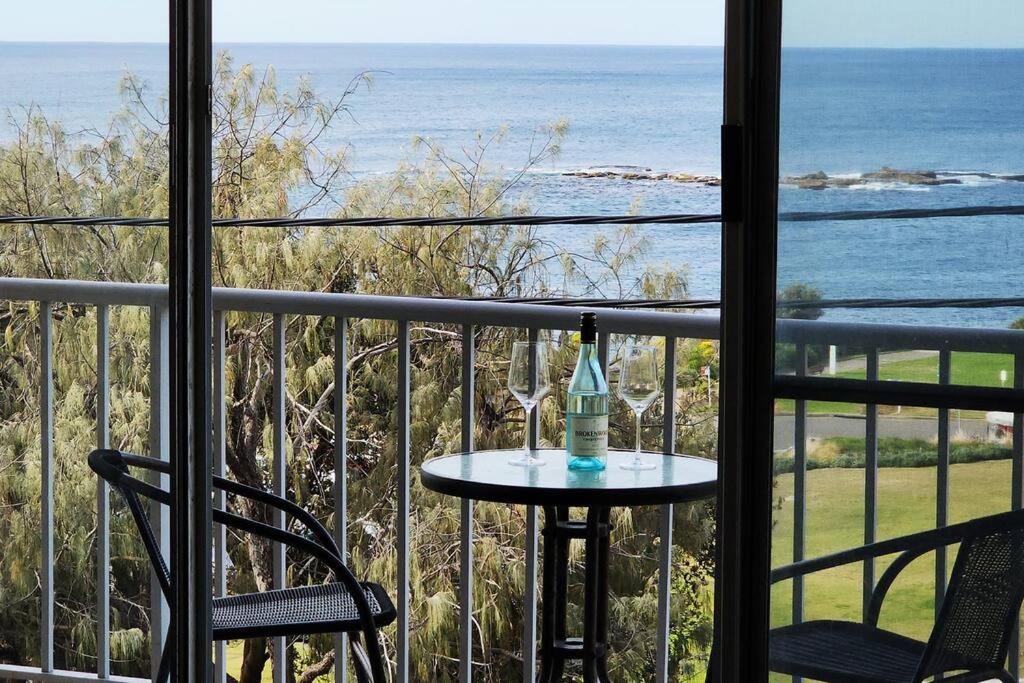 una mesa con una botella y una copa de vino en el balcón en Penthouse Apartment Ocean Views, en Sídney