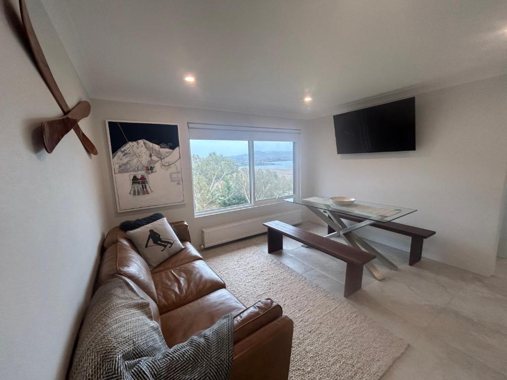 een woonkamer met een bank en een tafel bij House Matterhorn in Jindabyne
