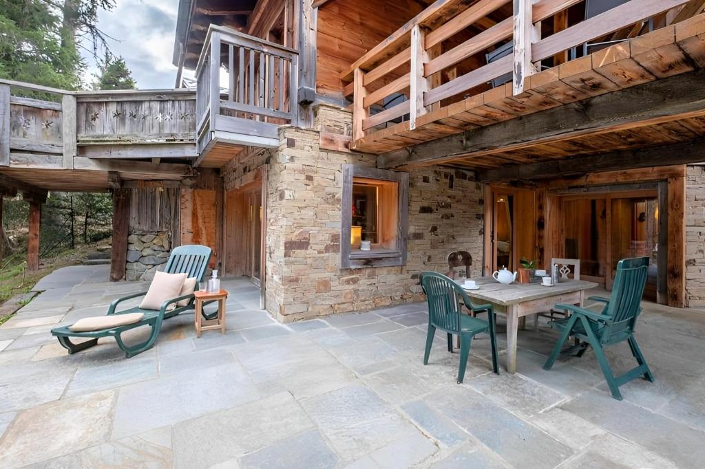 un patio avec une table et des chaises et un bâtiment dans l'établissement Chalet Ananda avec Sauna, Baignoire Balnéo et Terrasse, à Chamonix-Mont-Blanc