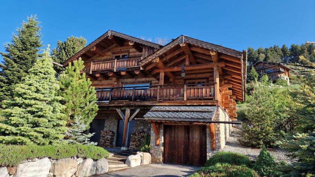 a log home with a deck on the side of it at Chalet Nanook, charme et luxe Pyrénéen in Bolquere Pyrenees 2000