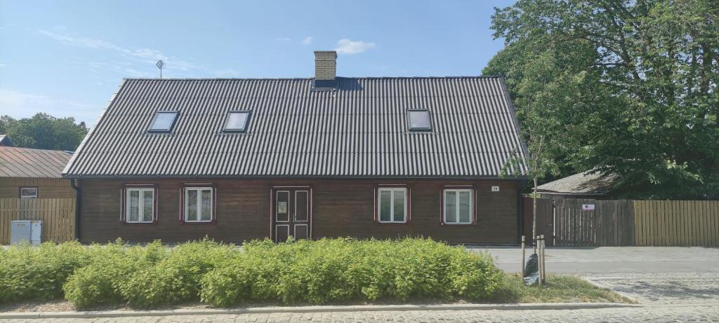a brown house with a roof and some bushes at 36 Posti in Haapsalu
