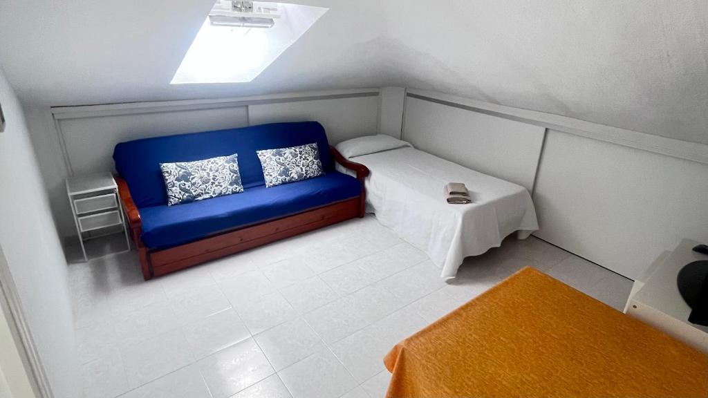 niewielka sypialnia z niebieską kanapą i stołem w obiekcie apartamento abuhardillado w mieście Cuchia