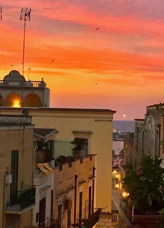 una calle de la ciudad con edificios y una puesta de sol en Casa Vacanze R&G La Marra, en Barletta