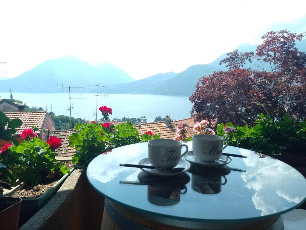 2 tazas de café sentadas en una mesa en un balcón en La Pergola, en Bellano