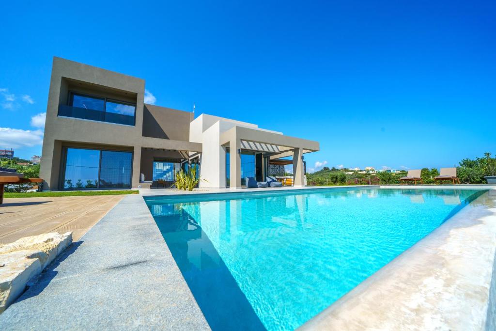 a swimming pool in front of a house at ISKIOS Premium in Agia Marina Nea Kydonias