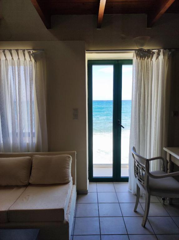 a living room with a couch and a view of the ocean at Thalassa Apartments in Rethymno