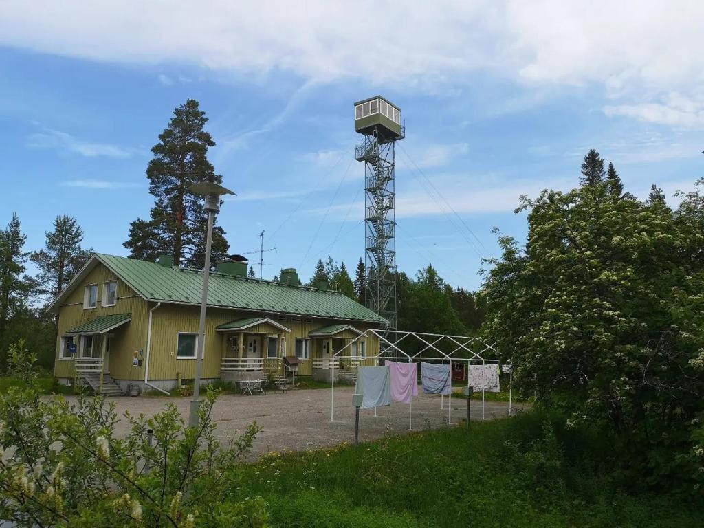 Una casa amarilla con una torre encima. en Raate Guest House en Suomussalmi