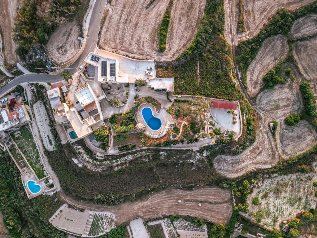 an overhead view of a house with a yard at Luxury Farmhouse Villa surrounded with Nature & Farm Animals Alpacas etc in Għasri