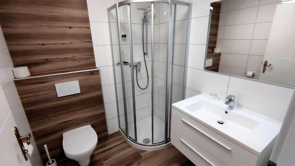 ein Bad mit einer Dusche, einem Waschbecken und einem WC in der Unterkunft Motel Maria in Steyr