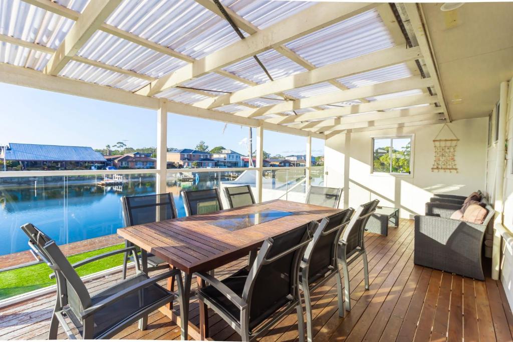 a dining room with a wooden table and chairs at Cockatoo House in Sussex inlet
