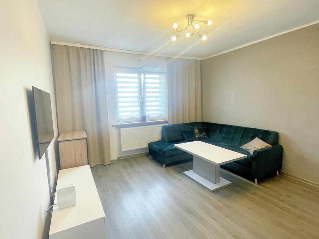 een woonkamer met een bank en een tafel bij Apartament Pyskowice Centrum in Pyskowice
