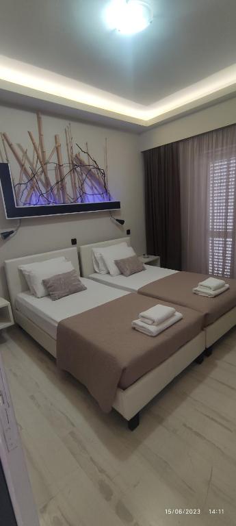 a bedroom with two beds with towels on them at olivegrove in Sidari