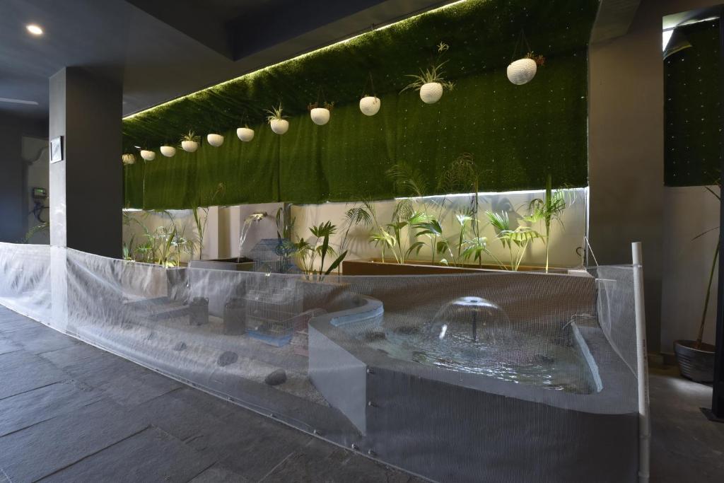 a bathroom with a fountain and plants on the wall at White Town By Ashoka Group in Udaipur