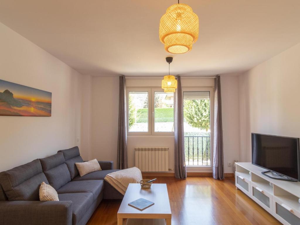 a living room with a couch and a tv at Apartamento Holidea El rincón de Arce in Oruña