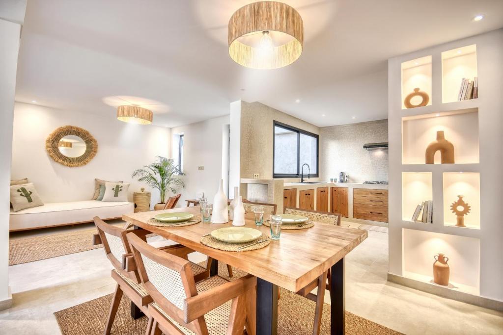 a kitchen and dining room with a wooden table and chairs at Villa Bali Cocoon - Piscine - luxe - 4 or 5 Px in Agadir