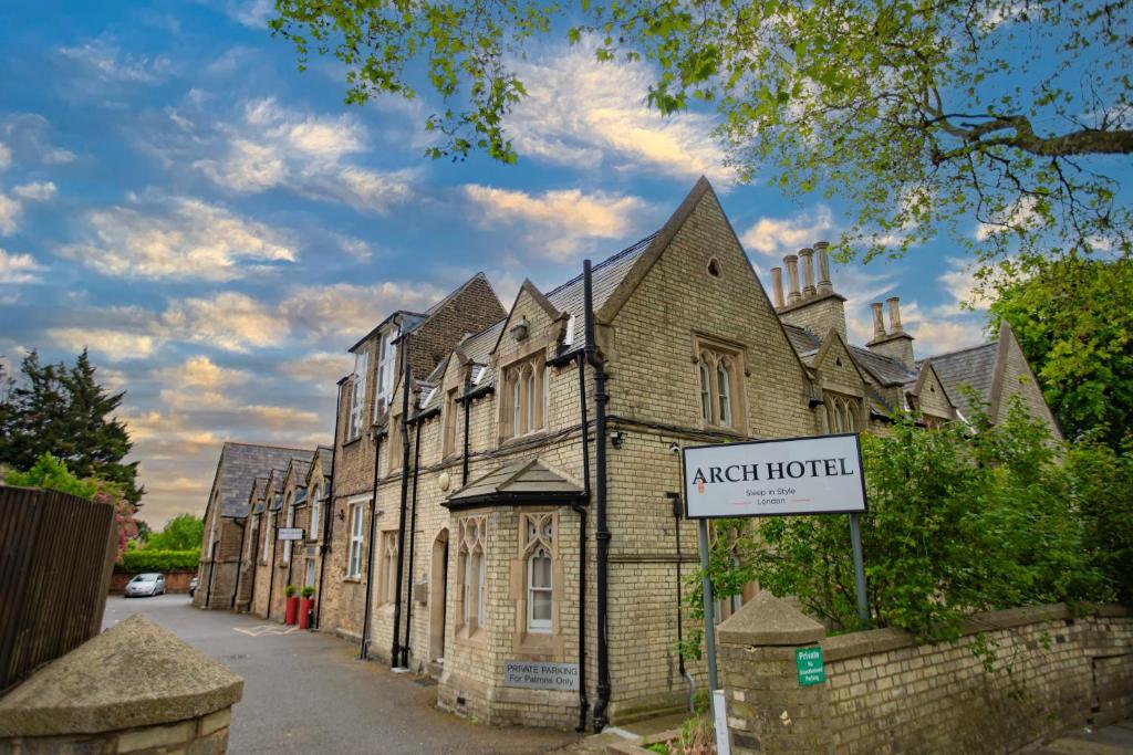 un vieux bâtiment avec un panneau devant lui dans l'établissement Arch Hotel, à Londres