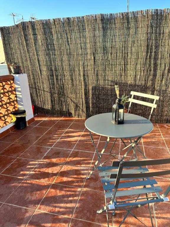uma mesa e cadeiras num pátio com uma cerca em A Casa do Tio Joaquim em Montemor-o-Novo