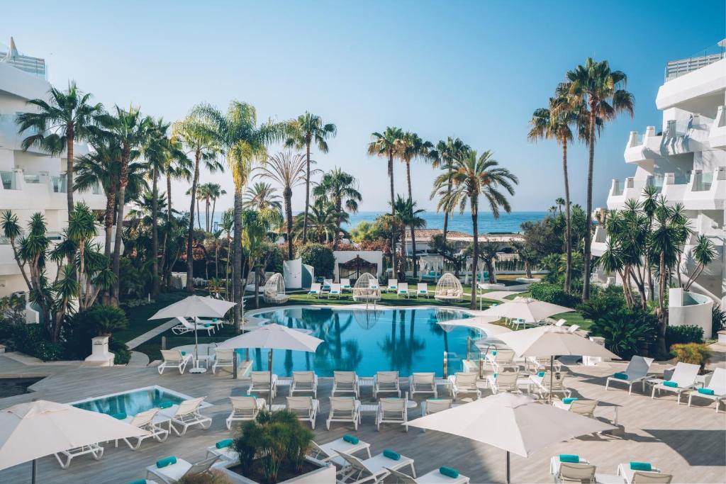 ein Luftblick auf ein Resort mit einem Pool und Palmen in der Unterkunft Iberostar Selection Marbella Coral Beach in Marbella