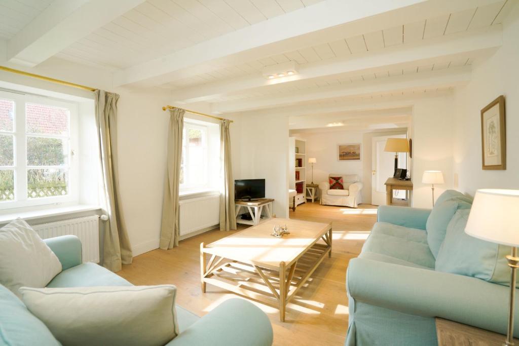 a living room with blue couches and a table at Strandhaus Falshöft 3 in Nieby