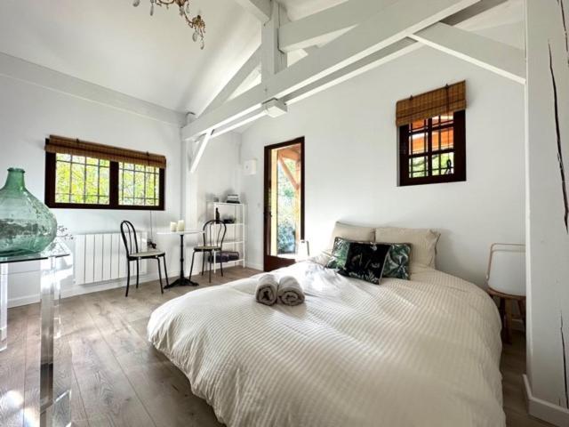 Un dormitorio blanco con una cama grande y una mesa en Chambre d'hôtes Cabanon à 10 min d'Aix-en-Provence, en Aix-en-Provence