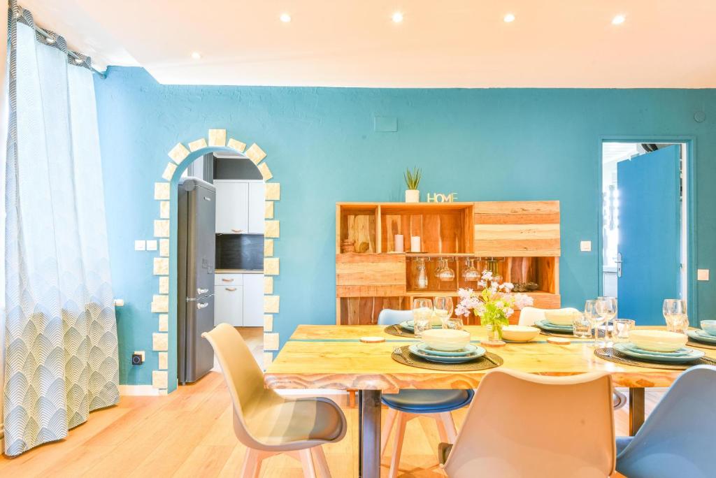 a dining room with blue walls and a table and chairs at A découvrir - L'Emergence in Strasbourg