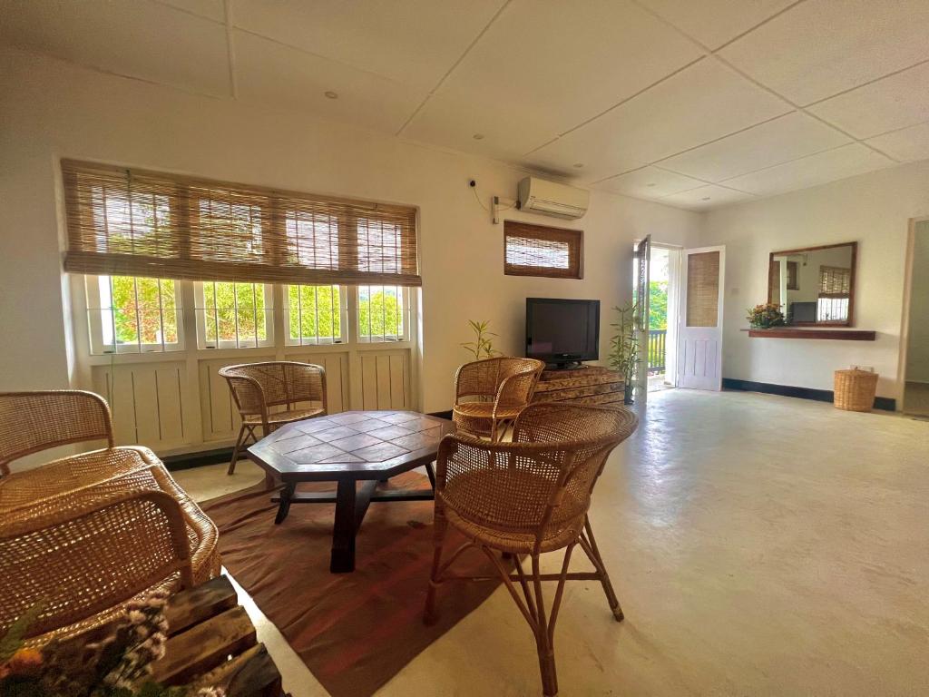 a living room with a table and chairs and a television at LOUIS LAKE VILLA in Kandy