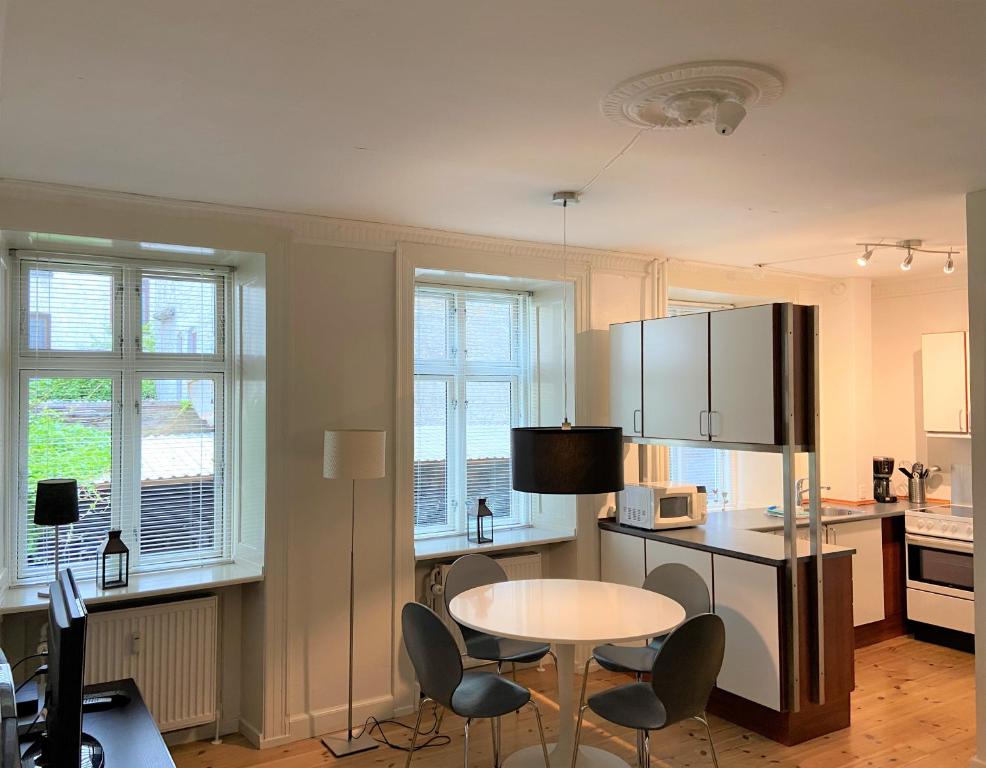 een keuken met een tafel en stoelen en een koelkast bij City Apartments 114 in Kopenhagen