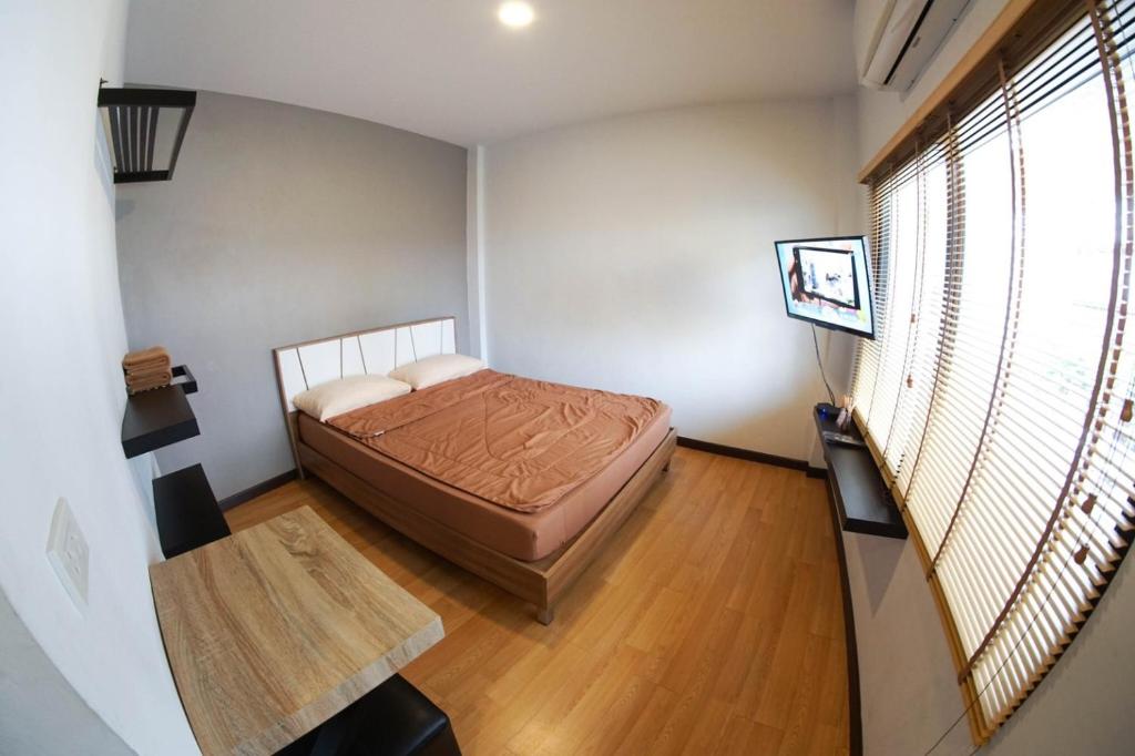 een kleine slaapkamer met een bed en een televisie bij Inn Trog And Inn Soi in Bangkok