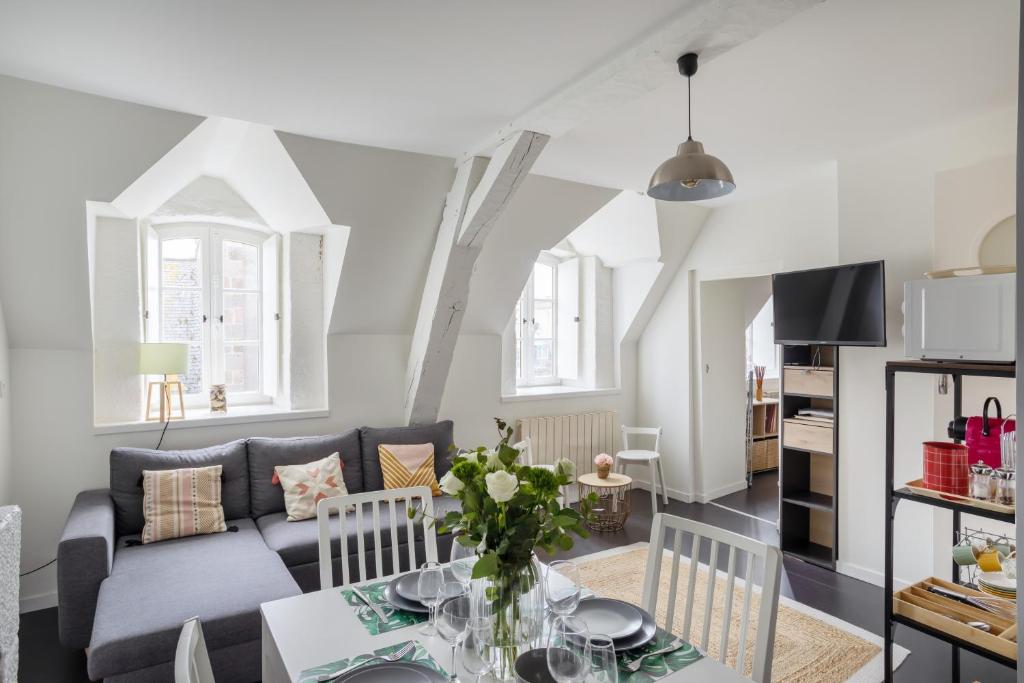 uma sala de estar com um sofá e uma mesa em L'Armateur - Appartement intramuros - plage - St Malo em Saint Malo