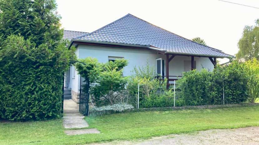 una casa blanca con una valla en el patio en An-Ta Nyaraló Fonyód, en Fonyód