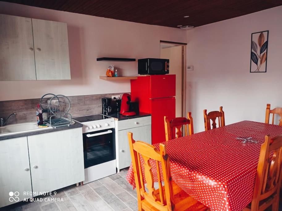 a kitchen with a table and a red refrigerator at Calme et détente dans une maison proche de la mer in Neufchâtel-Hardelot