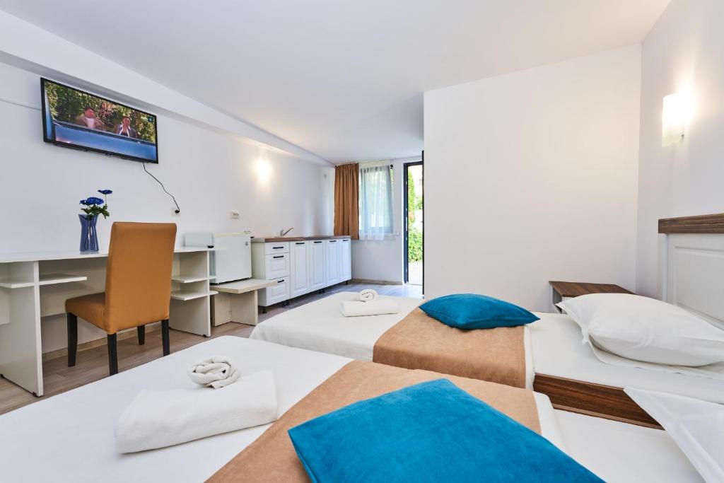 クルジュ・ナポカにあるPension Moraのベッド2台とデスクが備わるホテルルームです。