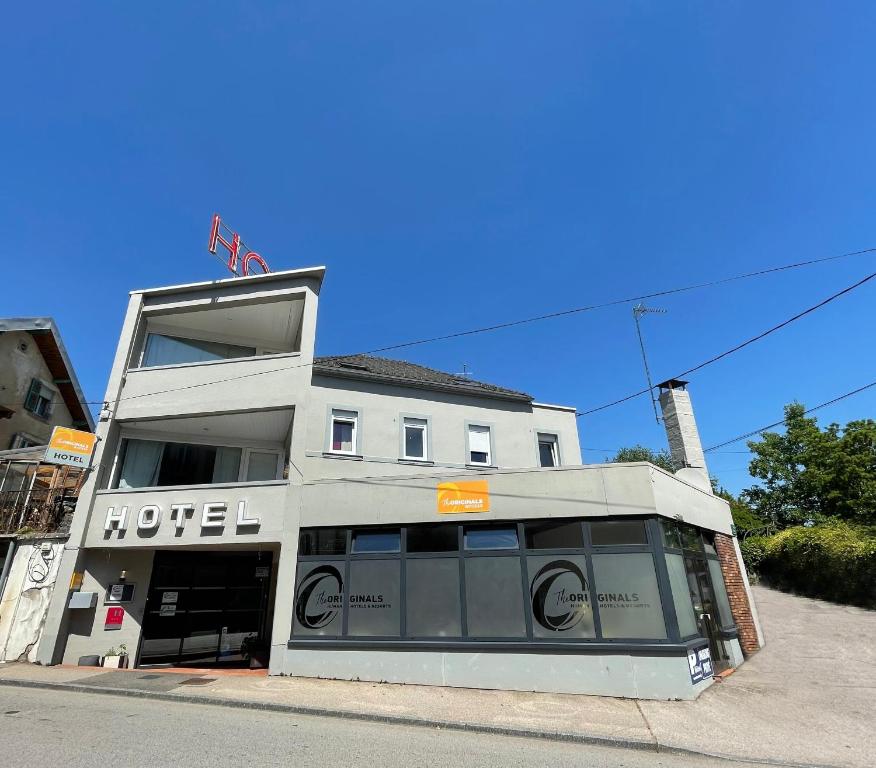 a hotel building on the corner of a street at The Originals Access, Hôtel Arum, Remiremont (Inter-Hotel) in Remiremont