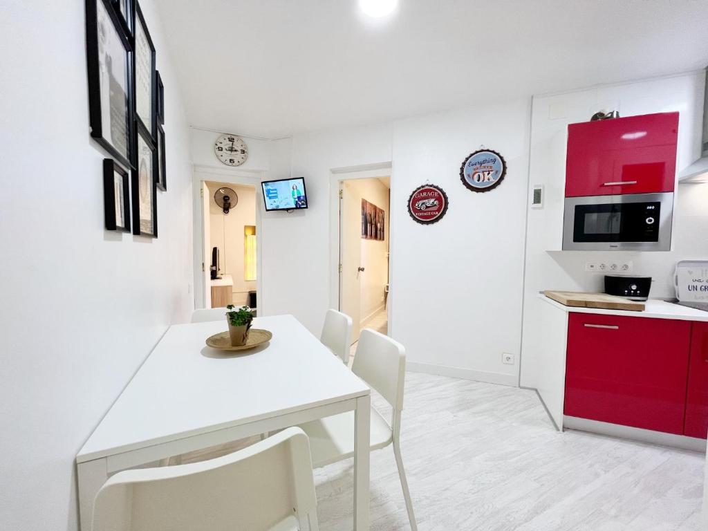 cocina y comedor con mesa blanca y sillas en Suite Miro Eixample Barcelona, en Barcelona