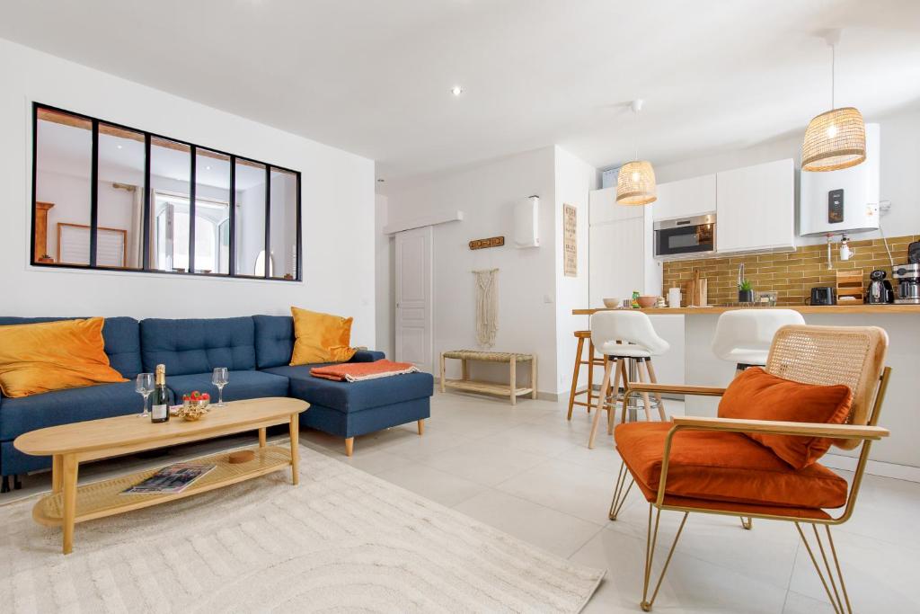 un salon avec un canapé bleu et une table dans l'établissement Le Cocon Saint Tropez YourHostHelper, à Saint-Tropez
