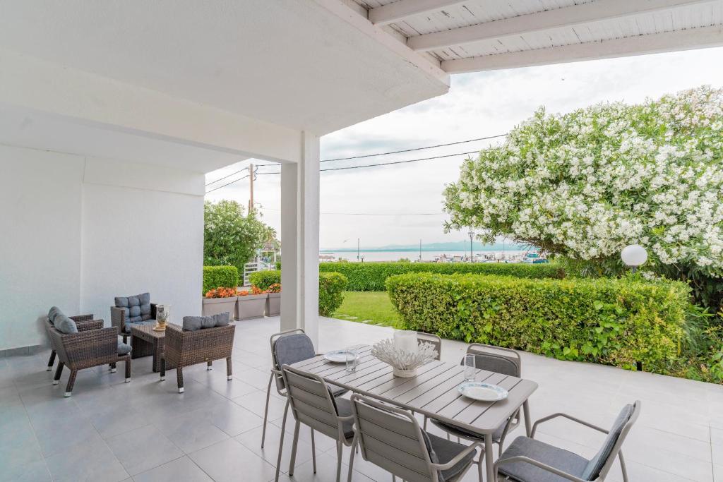 a dining room with a table and chairs on a patio at Seashell by halu! in Nea Fokea