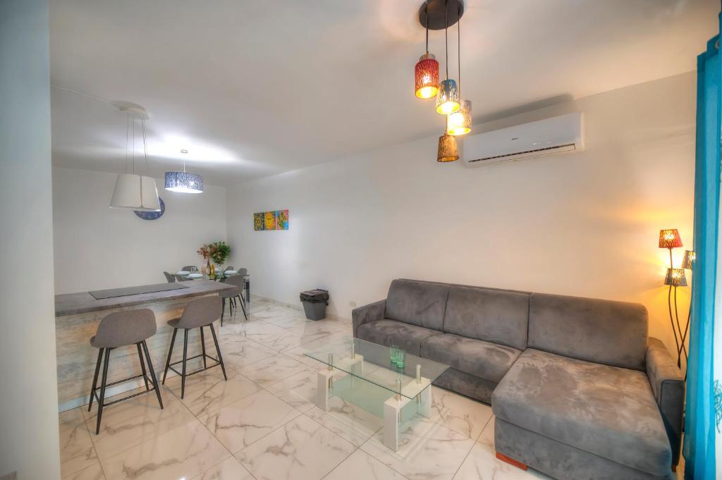 uma sala de estar com um sofá e uma mesa em Spacious & modern 3 bedroom near seafront JBOR1-1 em Il-Gżira