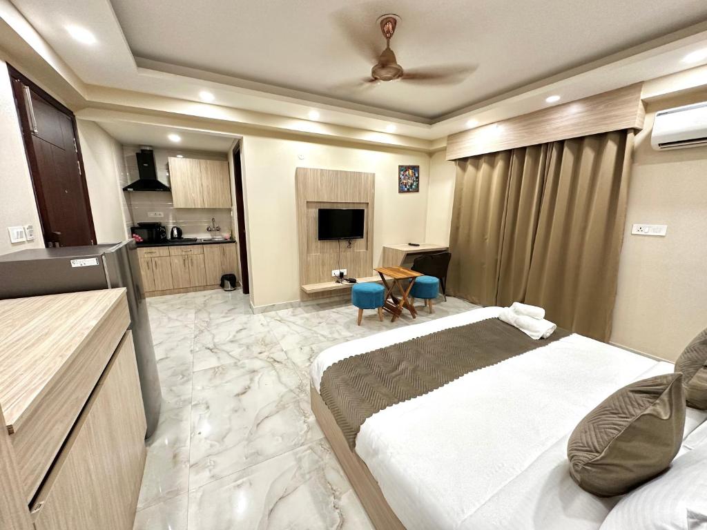 a bedroom with a large bed and a kitchen at Paras Studios By The Lodgers-Serviced Apartments Near Artemis Hospital Gurgaon in Gurgaon
